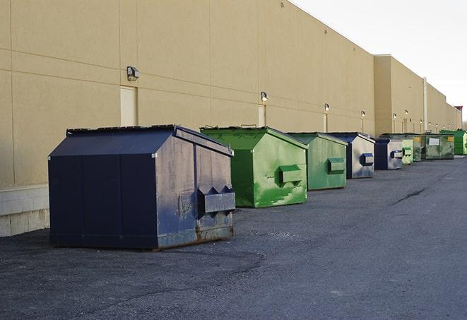 a waste management truck unloading into a construction dumpster in Blackshear, GA